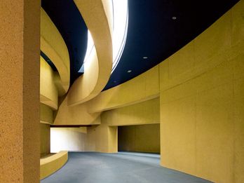 混凝土的赭色色调跟随着建筑结构不断流动，并反射出将建筑的不同层次兼容并包的整体理念。
